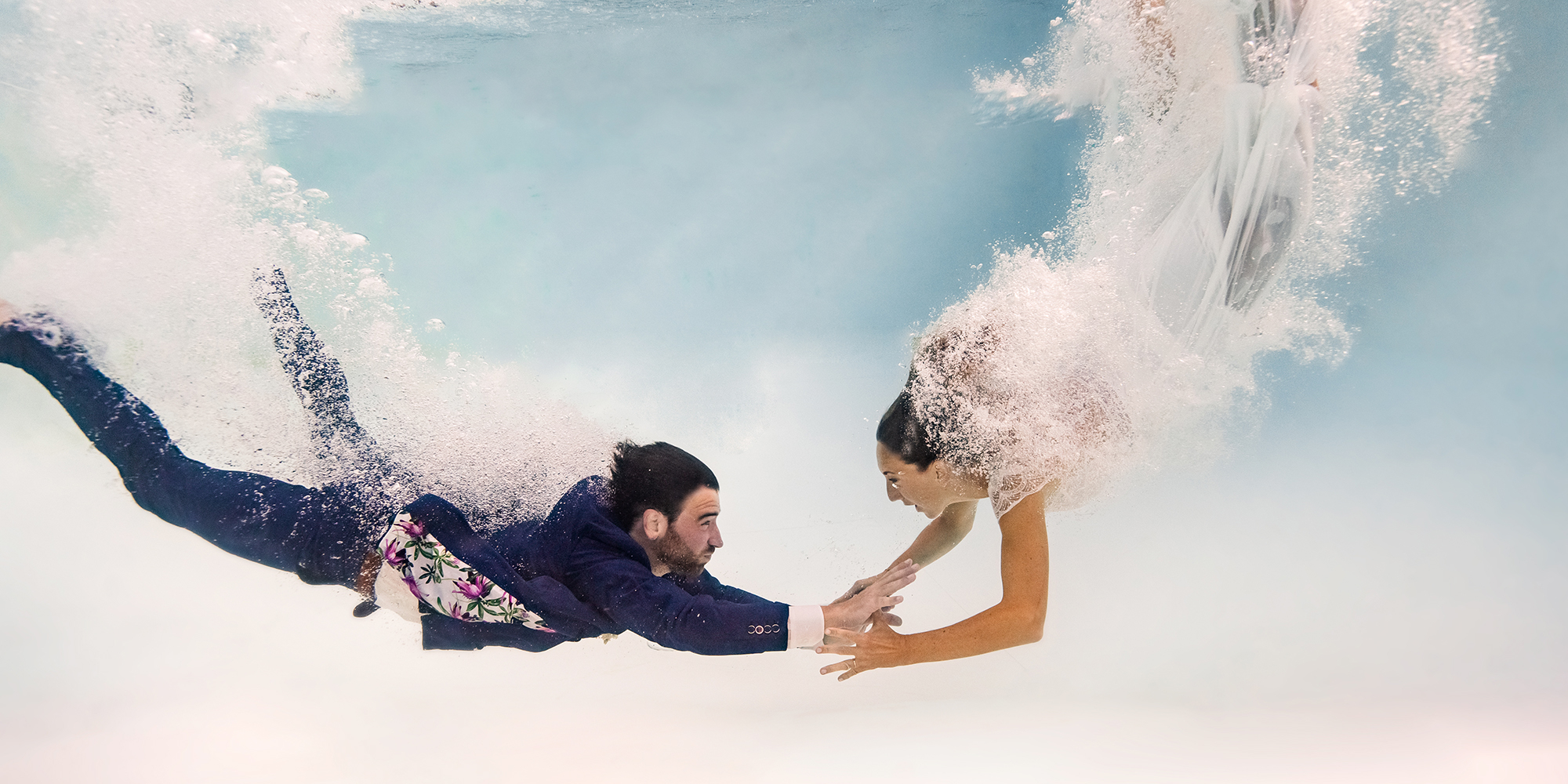 Photo de couple de mariage sous l'eau dans une piscine.